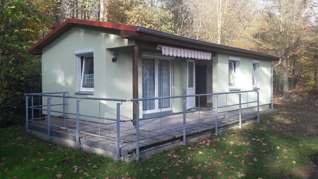 una piccola casa bianca con un ampio ponte di Ferienhaus Cornell a Feldberg