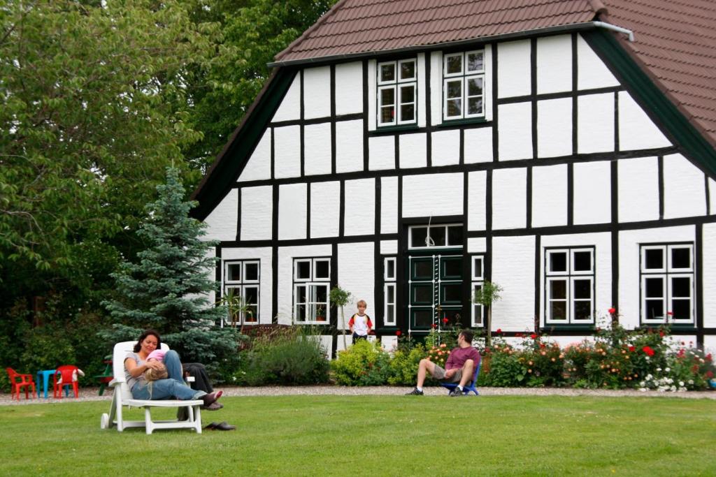 un grupo de personas sentadas en sillas frente a una casa en Ferienwohnung "Seestern" en Hinrichsdorf