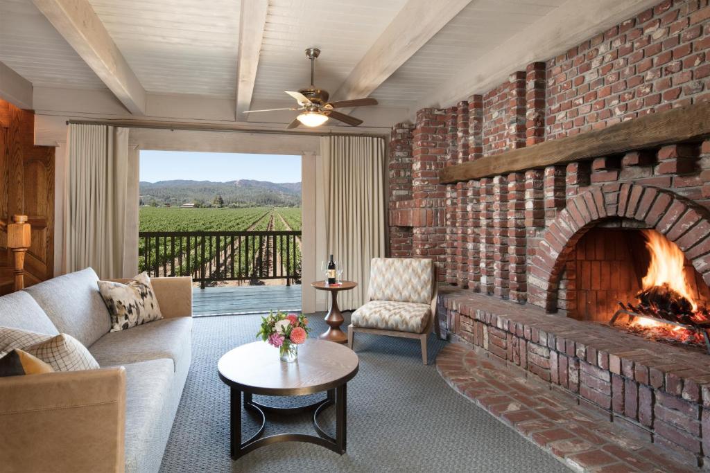 a living room with a brick wall with a fireplace at Harvest Inn in St. Helena