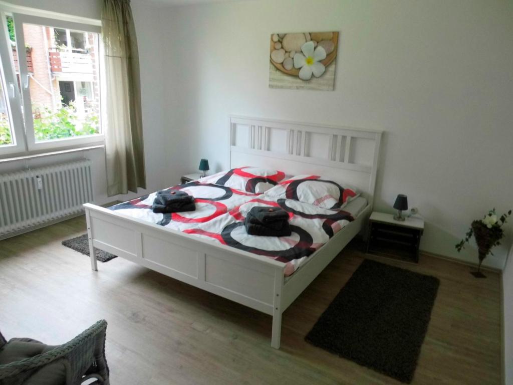 a bedroom with a bed with a red and white comforter at Maggie's Goode Stuuv in Heiligenhafen