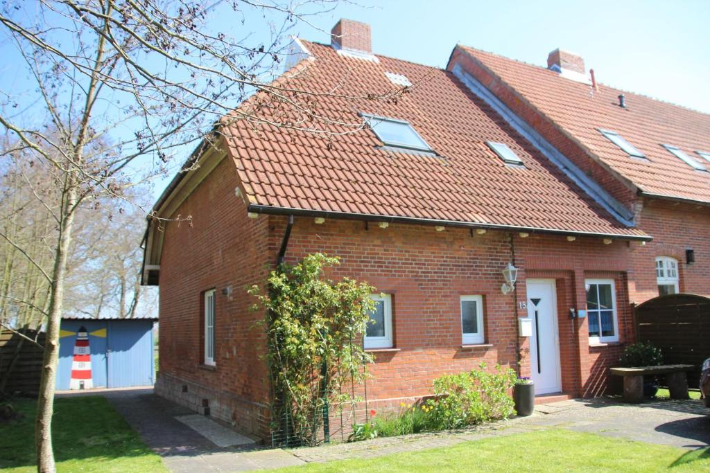 una casa in mattoni rossi con tetto rosso di Haus Romy a Hagermarsch