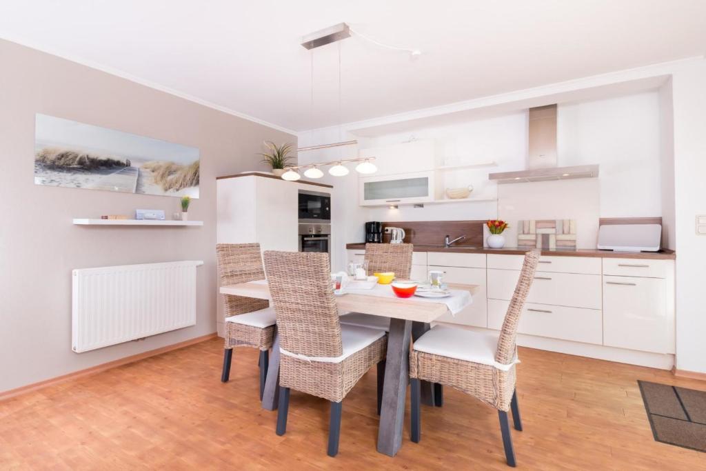 a kitchen and dining room with a table and chairs at M5 Bungalow - Apartmenthaus Marienburger Str 4 - FERIENDOMIZIL HOLLICH in Grömitz