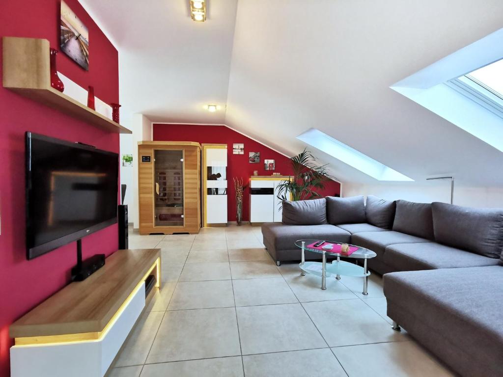 ein Wohnzimmer mit einem Sofa und einem Flachbild-TV in der Unterkunft Ferienwohnung Schöne Auszeit in Markkleeberg