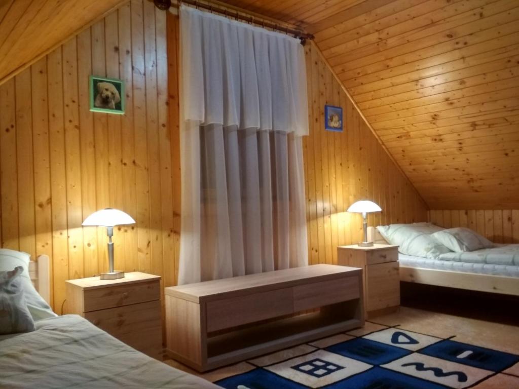 een slaapkamer met 2 bedden en 2 lampen op tafels bij Apartman Daniel in Balatonfőkajár