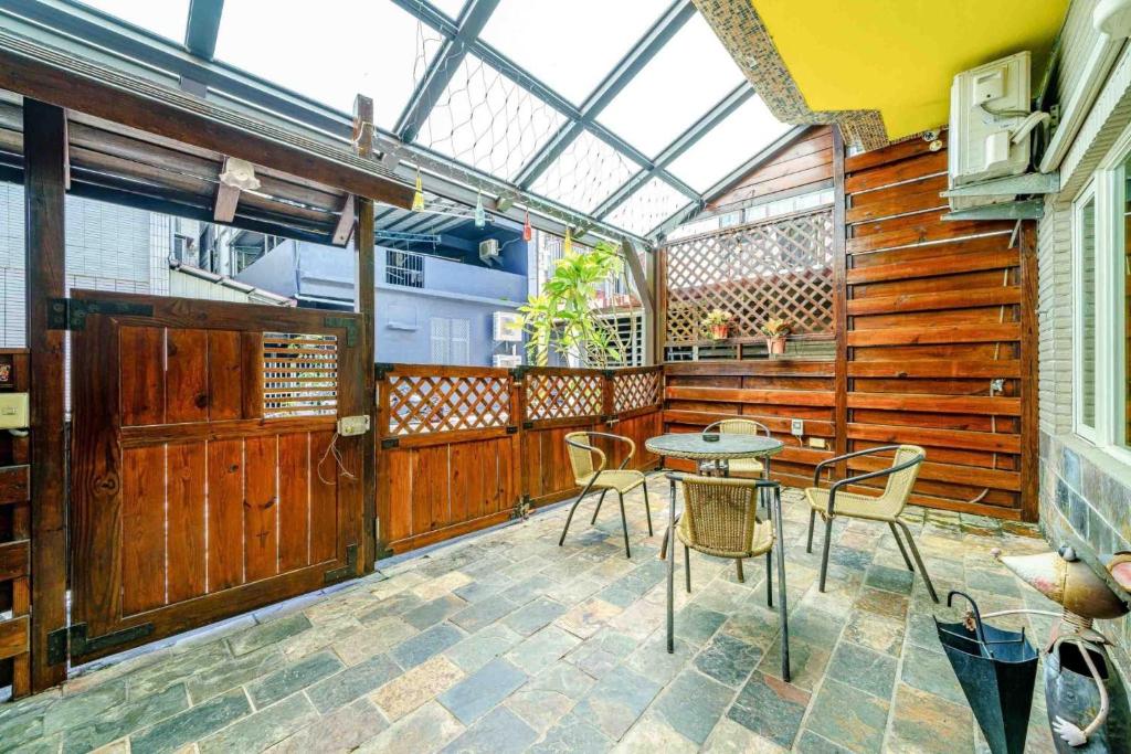a patio with a table and chairs and a glass ceiling at Sunny Homestay in Ji&#39;an