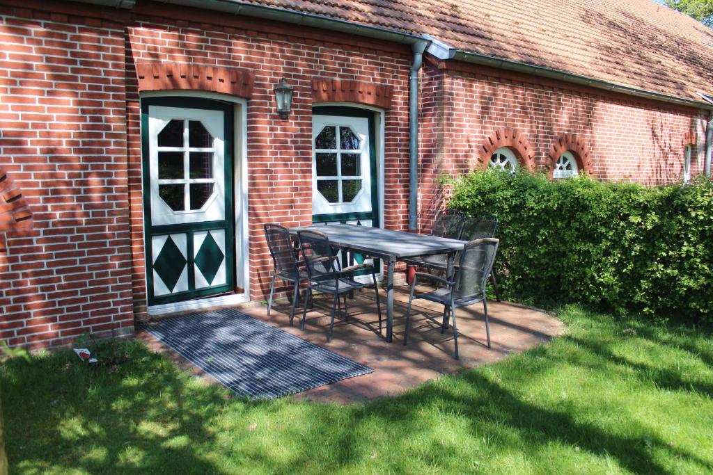 a table and chairs in front of a brick building at Ferienwohnung 4 Struven Hus in Lehe