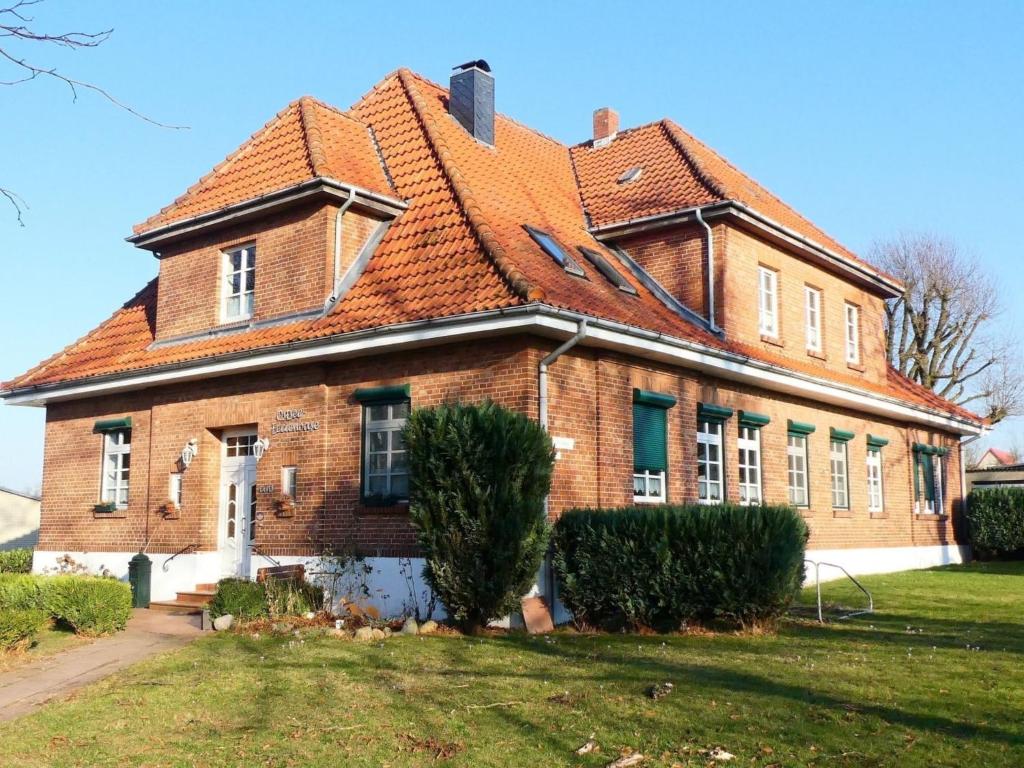 une ancienne maison en briques avec un toit rouge dans l'établissement Ostsseeferienoase Steilküste, à Klütz