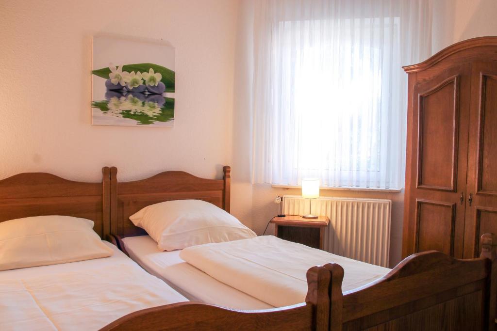 2 camas individuales en un dormitorio con ventana en Familienhof Brüning - Terrassenwohnung, en Meppen