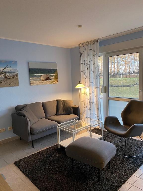 a living room with a couch and chairs and a table at Seestraße 70, Ap 30 in Zingst