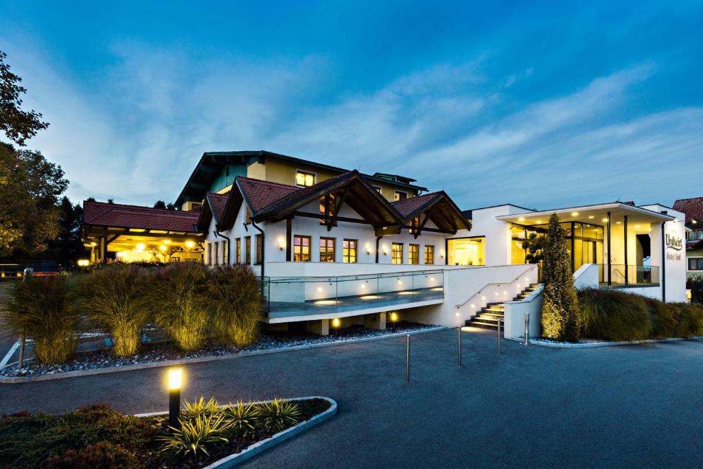 a large house with lights on in a driveway at Hotel & Restaurant Urdlwirt in Premstätten