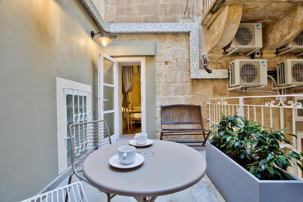 una mesa blanca en el balcón de un edificio en Chateau La Vallette - Grand Harbour Suite, en La Valeta