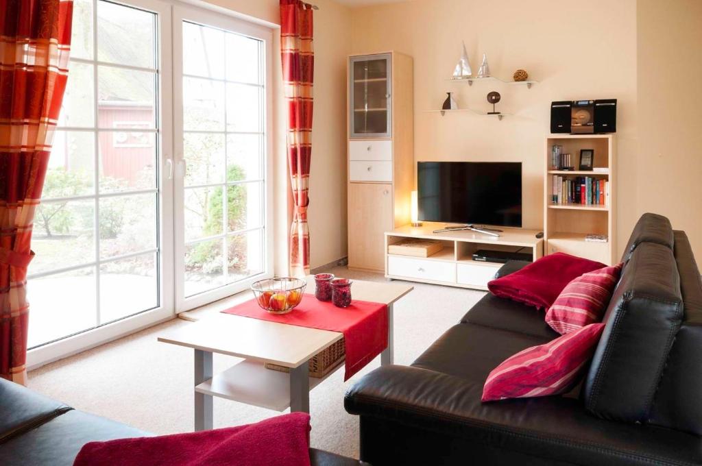 ein Wohnzimmer mit einem Sofa und einem TV in der Unterkunft Friedenstraße 7 Whg 2 in Zingst