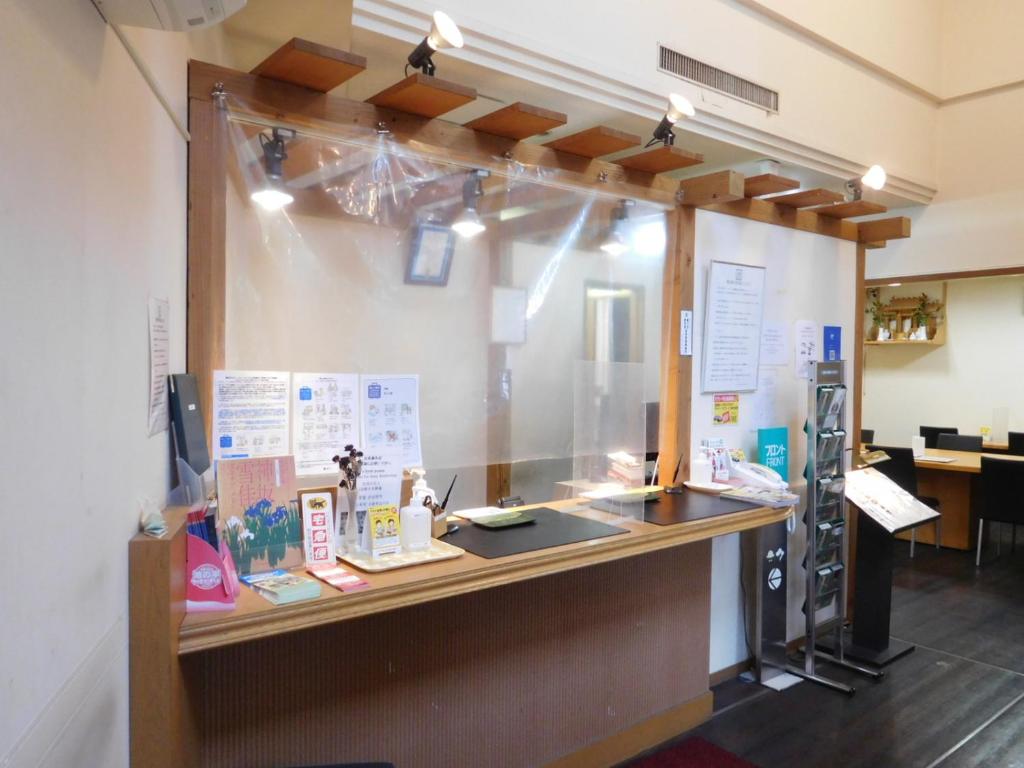a reception counter in a room with a window at Hotel Select Inn Nagano in Nagano