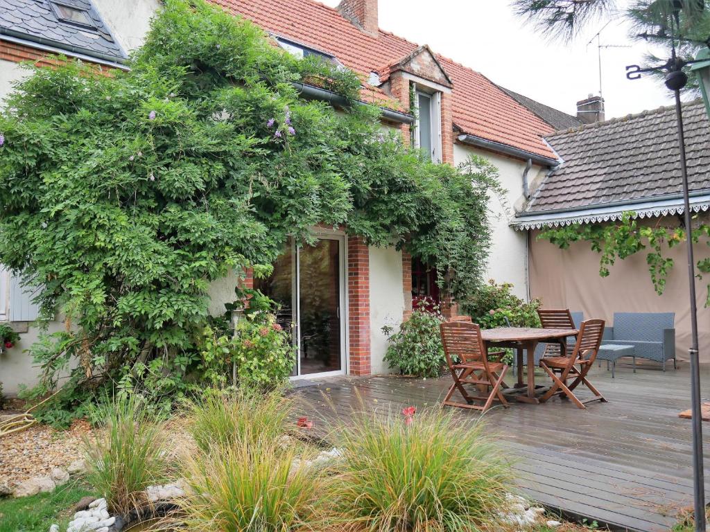 eine Holzterrasse mit einem Tisch und Stühlen auf einem Haus in der Unterkunft Gîte Olivet, 3 pièces, 4 personnes - FR-1-590-174 in Olivet