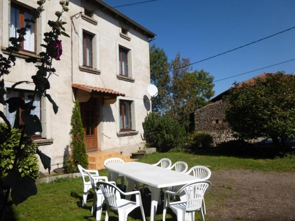 uma mesa branca e cadeiras em frente a um edifício em Gîte Solignac-sur-Loire, 4 pièces, 6 personnes - FR-1-582-116 em Solignac-sur-Loire