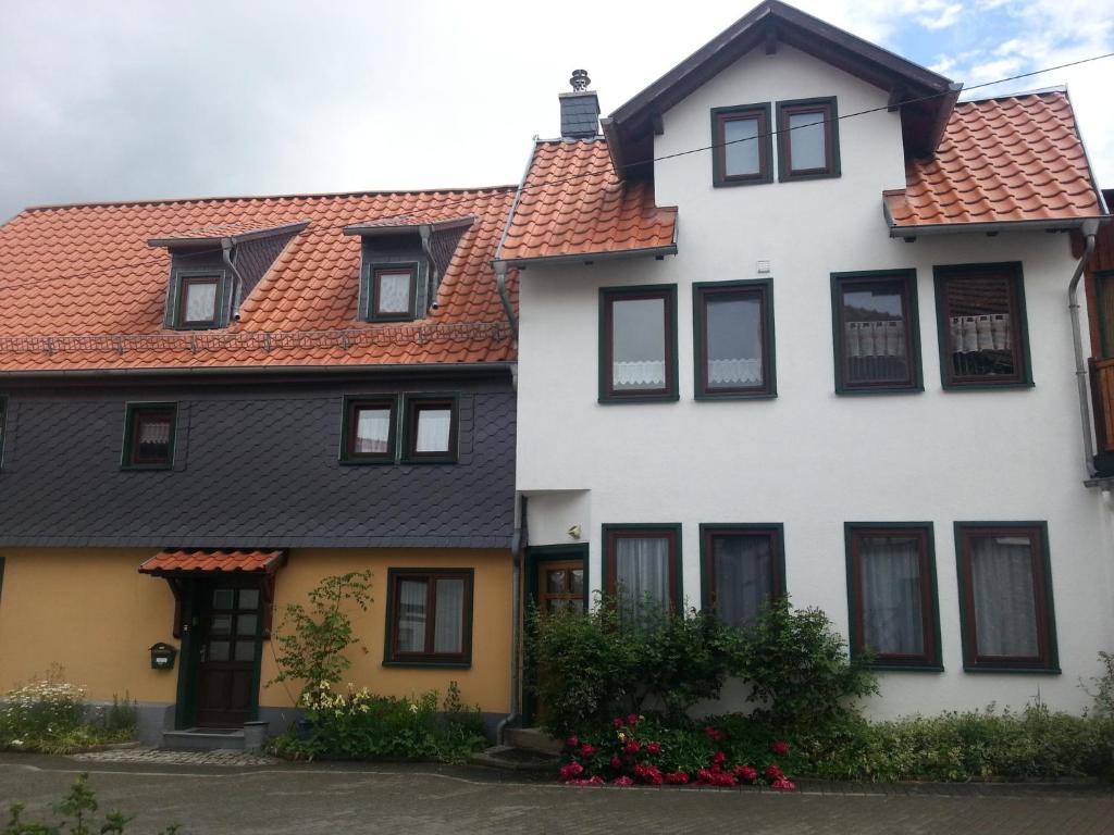 Biały dom z czerwonym dachem w obiekcie Haus Saskia w mieście Wutha