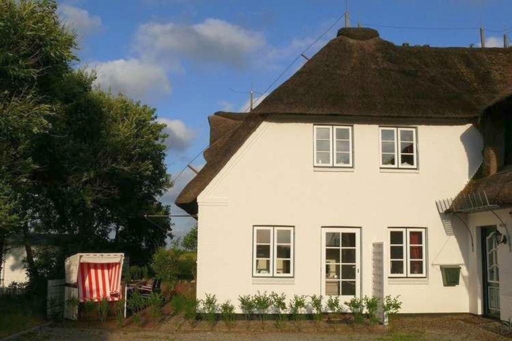 a white house with a thatched roof at Deichhof Whg18 in Dunsum