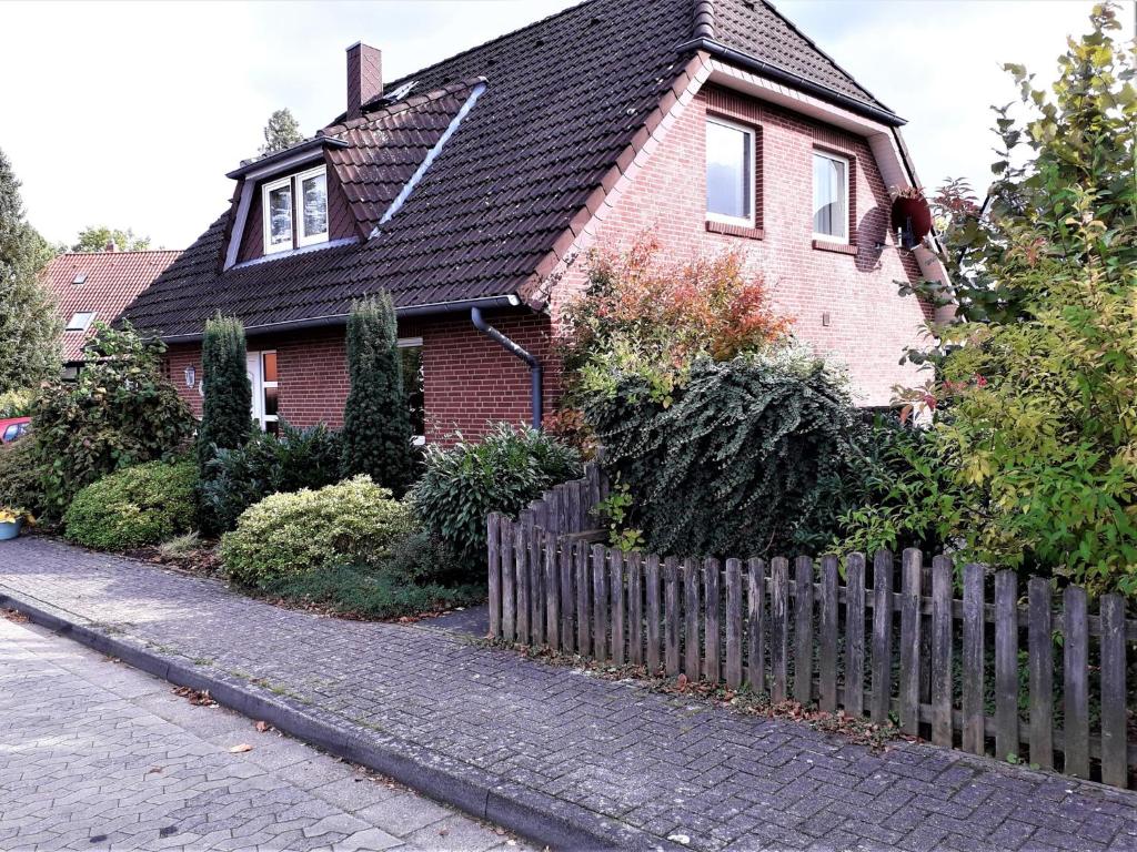 a red brick house with a wooden fence at Haus Tuti-No3 in zentraler Lage und doch im Grünen in Soltau