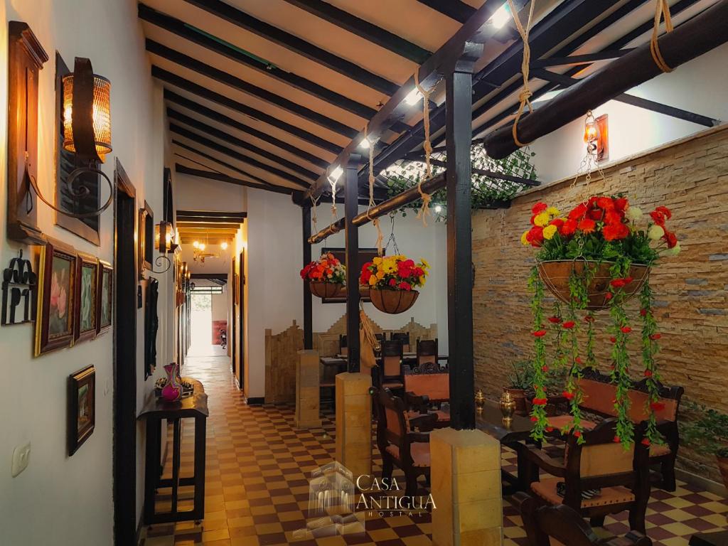 a restaurant with flowers in baskets on the wall at Hotel Boutique Casa Antigua in San Vicente de Chucurí