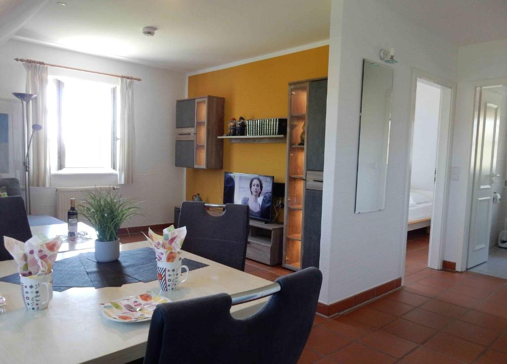 a living room with a dining table and a television at Ferienparadies Rugana C09 in Kreptitz