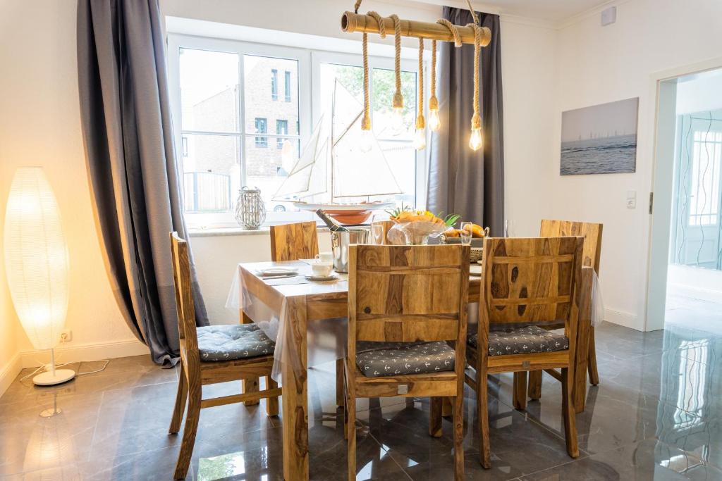 a dining room with a wooden table and chairs at Mien Tied MITTENMANG in Heiligenhafen