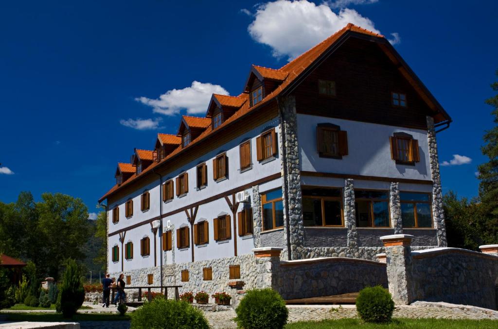 een groot wit gebouw met een bruin dak bij Hotel Gacka in Otočac