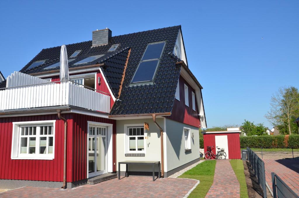 a red and white house with a black roof at Haus Lobster in Zingst