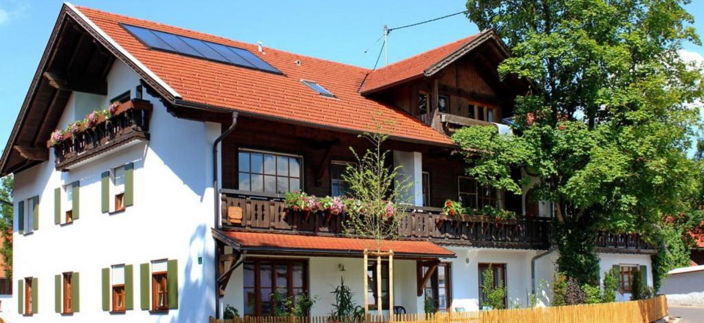 a house with a red roof with a balcony at Ferienwohnung Nr 3, Lechbruck-Prem, Allgäu in Prem