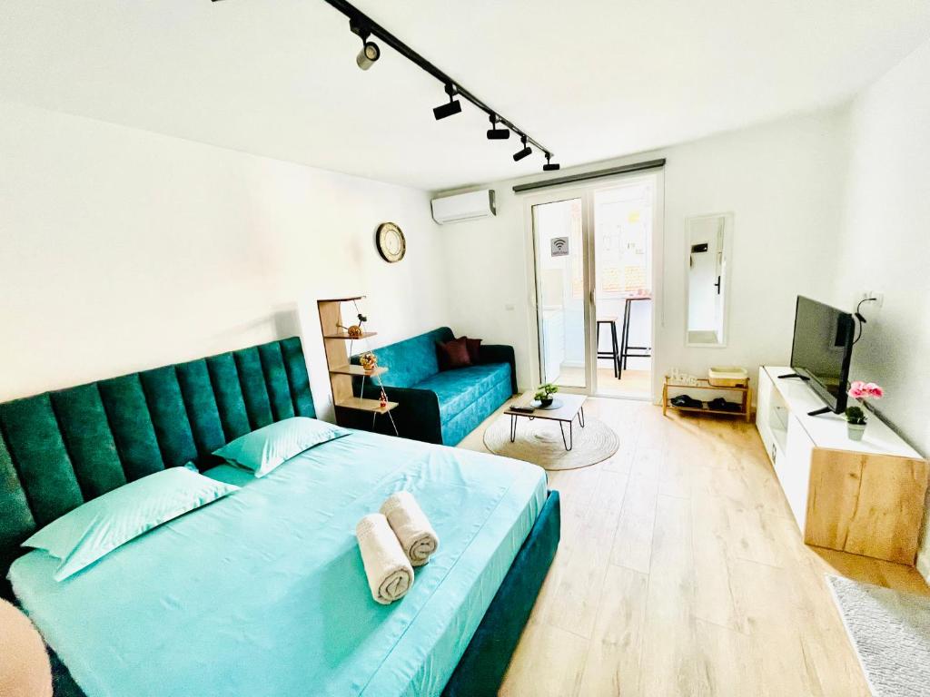 a bedroom with a blue bed and a blue couch at Central Studio Apartment 1, Tirana in Tirana