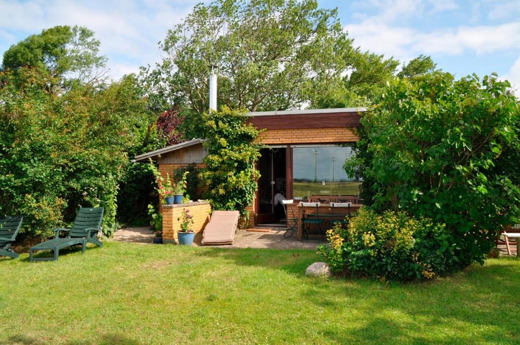 a small house in a yard with a bench at Ferienhaus Marienleuchte in Marienleuchte