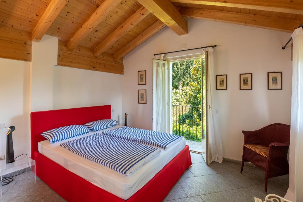 una camera con letto rosso e finestra di Flairhouse Parco a Gravedona
