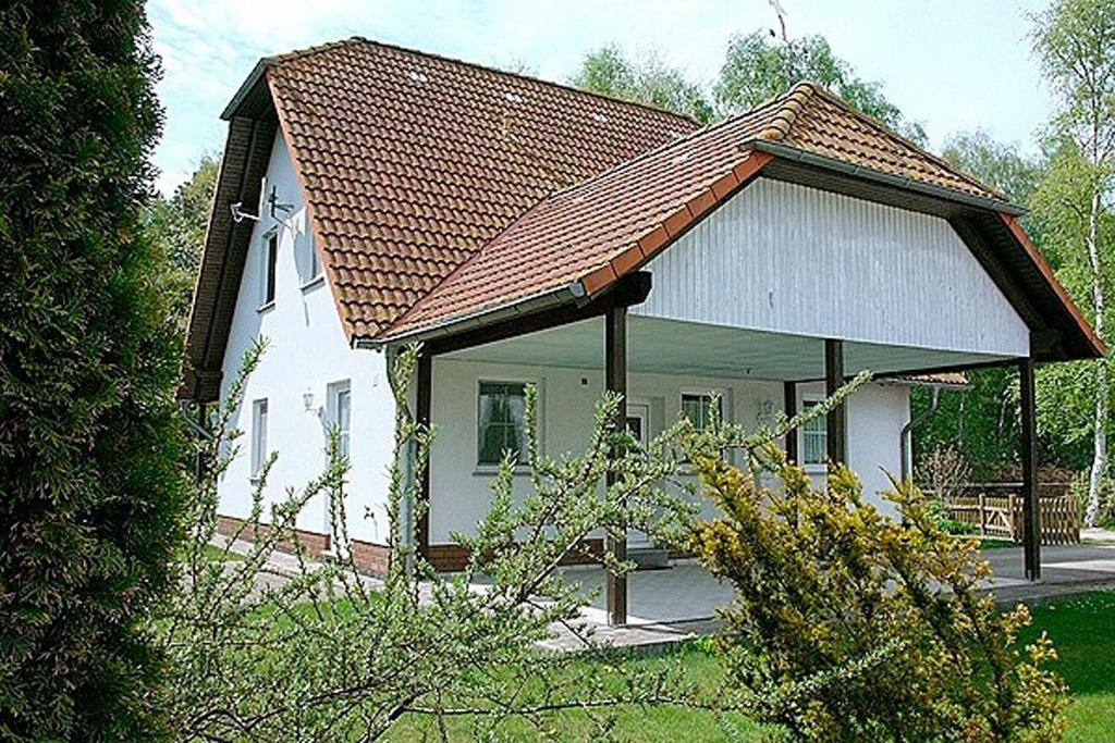 a small white house with a brown roof at Waldesruh - App 1 in Zingst