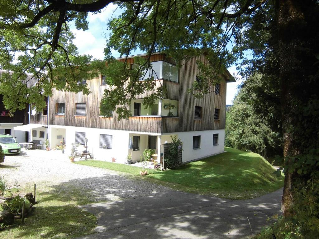 uma imagem de um edifício com um quintal em Ferienwohnung Maari em Hittisau