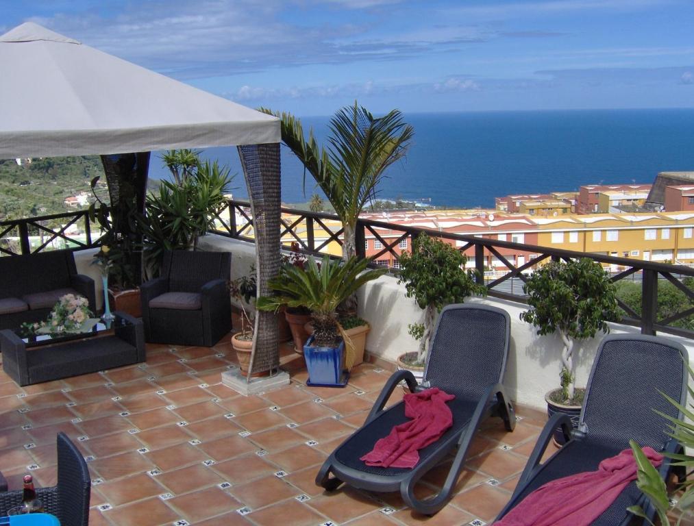 Un balcón con sillas y vistas al océano. en Apartment im englischen Stil mit Meerblick, en Icod de los Vinos
