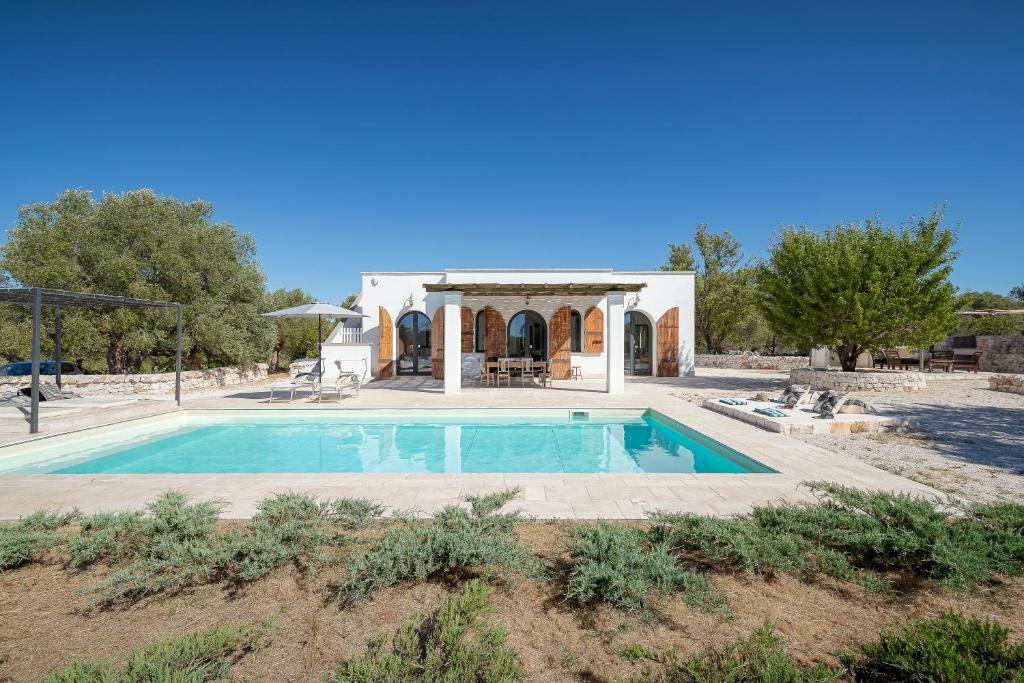 a villa with a swimming pool and a house at Cisternino Villa in Olive Groove in Cisternino