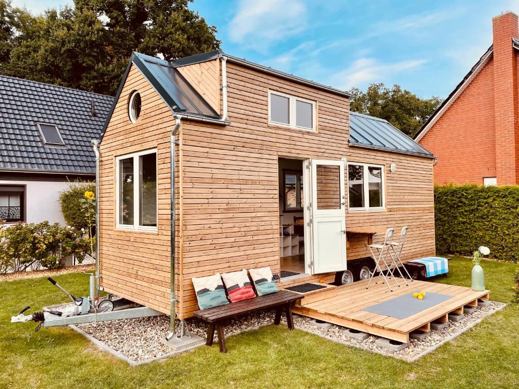 una casa pequeña con terraza en un patio en TINY HOUSE FLEESENSEE mit eigenem Garten und nur wenige Meter vom Seeufer, en Göhren-Lebbin