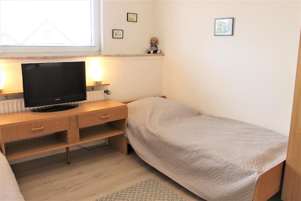 een slaapkamer met een bed en een televisie op een bureau bij Haus Barbara - Schwimmbad und Sauna im Haus- Whg 7 in Grömitz