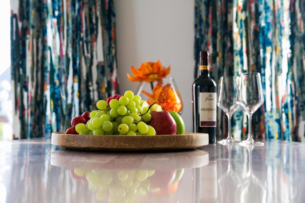 um prato de fruta numa mesa com uma garrafa de vinho em Apartment by Janzen E em Rheine