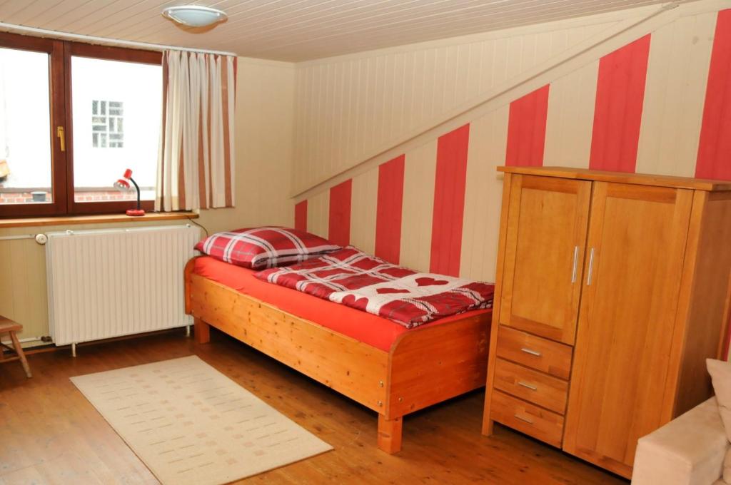 a bedroom with a bed and a cabinet and a window at Fischerhaus am Binnensee in Heiligenhafen