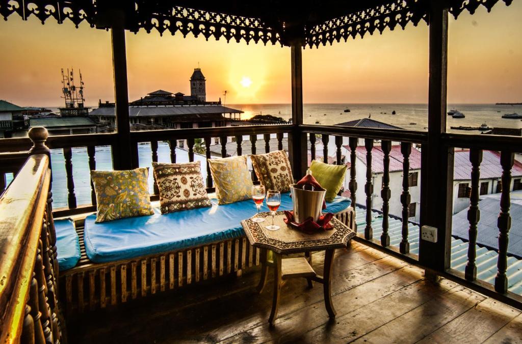 a bench on a balcony with a view of the ocean at Emerson on Hurumzi in Zanzibar City