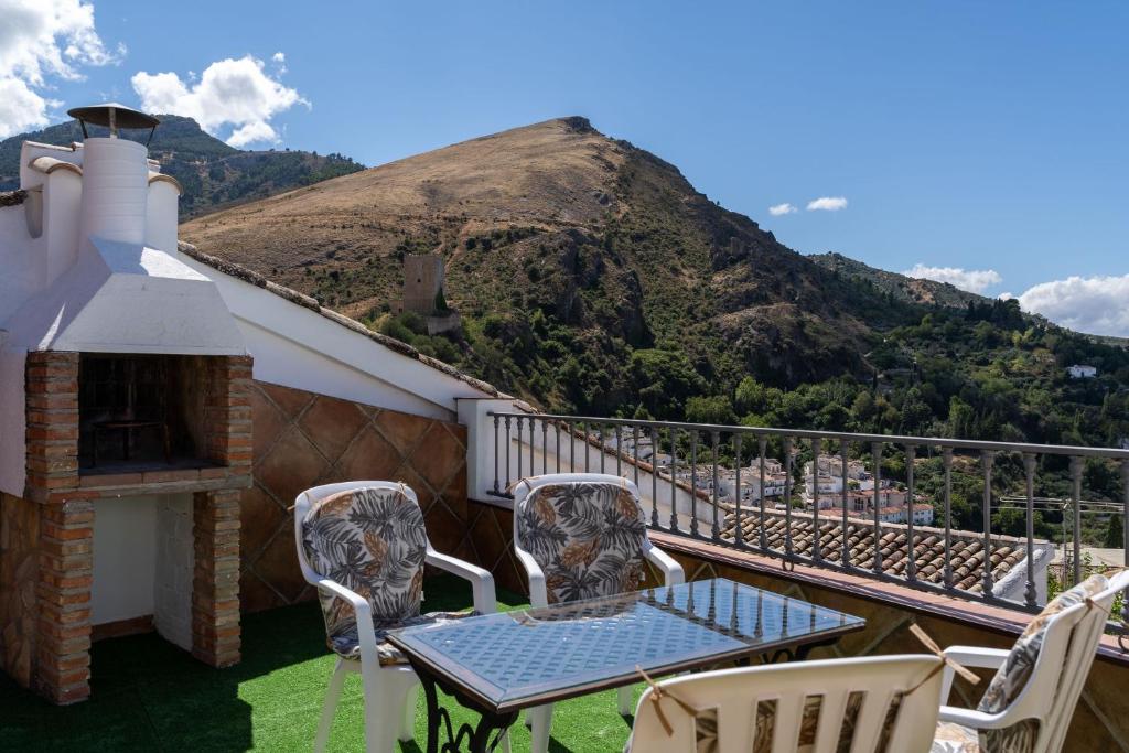 a balcony with a table and chairs and a mountain at La Casa de Esparto in Cazorla
