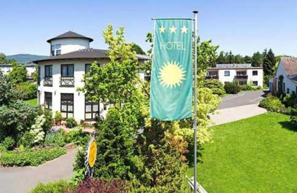 una bandera frente a una casa con patio en Hotel Garni Schick, en Oberursel