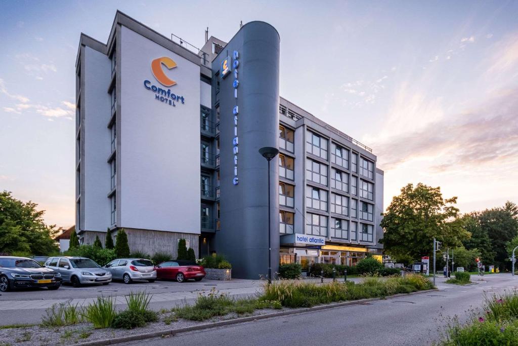 ein Hotel mit auf einem Parkplatz geparkt in der Unterkunft Comfort Hotel Atlantic Muenchen Sued in Ottobrunn