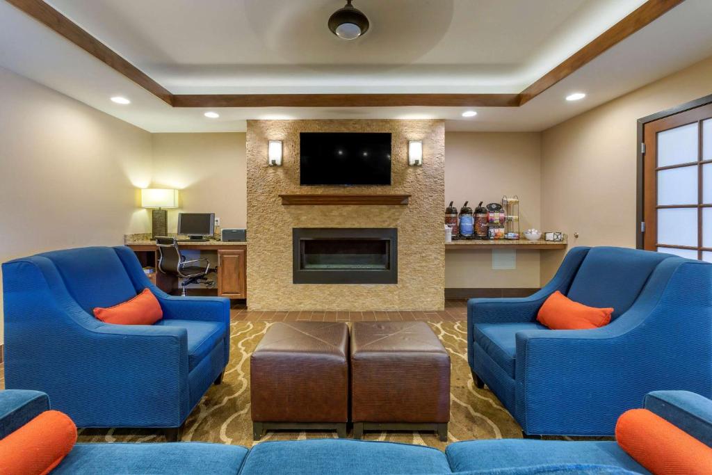 a living room with two blue chairs and a fireplace at Comfort Inn Medford North in Medford