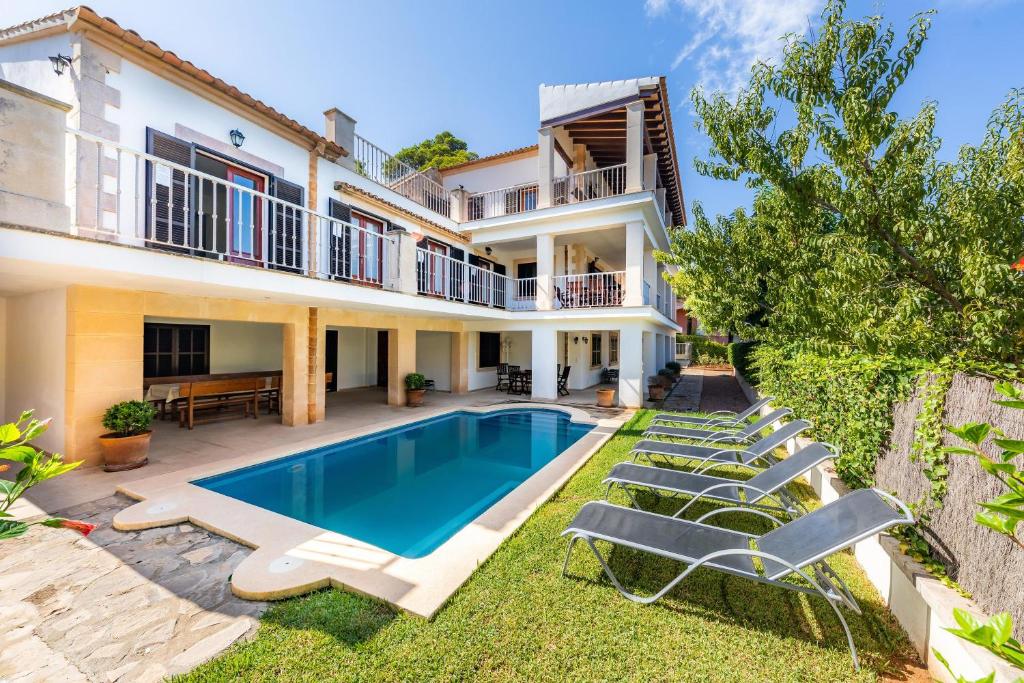 a villa with a swimming pool and lounge chairs at Gran Vista Mar in Alcudia