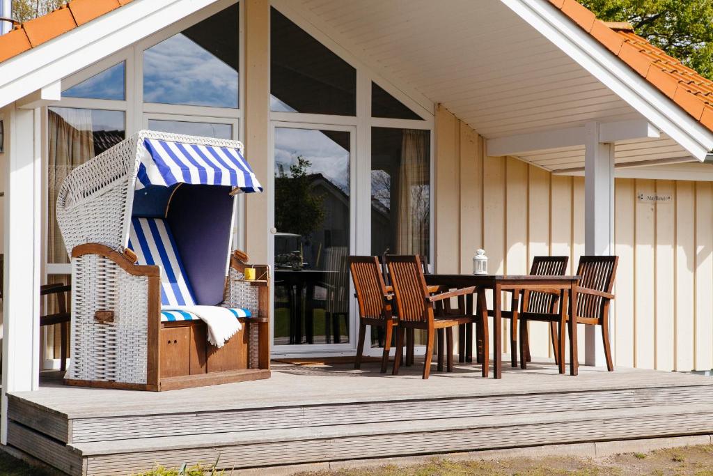 eine Terrasse mit einem Tisch und Stühlen auf einem Haus in der Unterkunft Typ A "Morning Star" - Kleiner-Belt-Haus- in Pelzerhaken