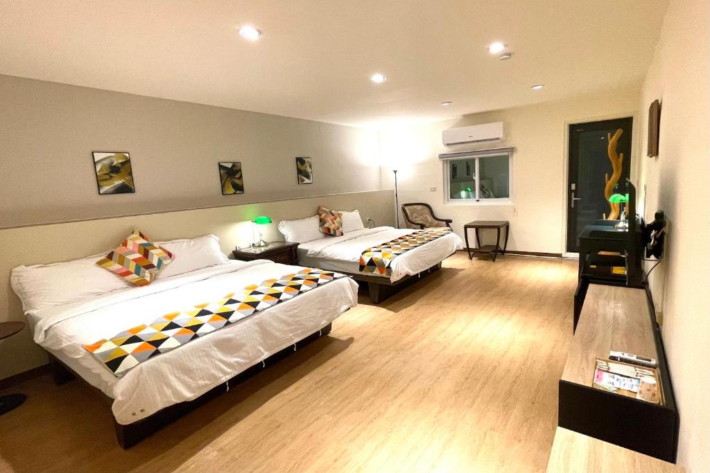 a hotel room with two beds in a room at 墾丁聚點旅棧 2Ps Hotel in Kenting