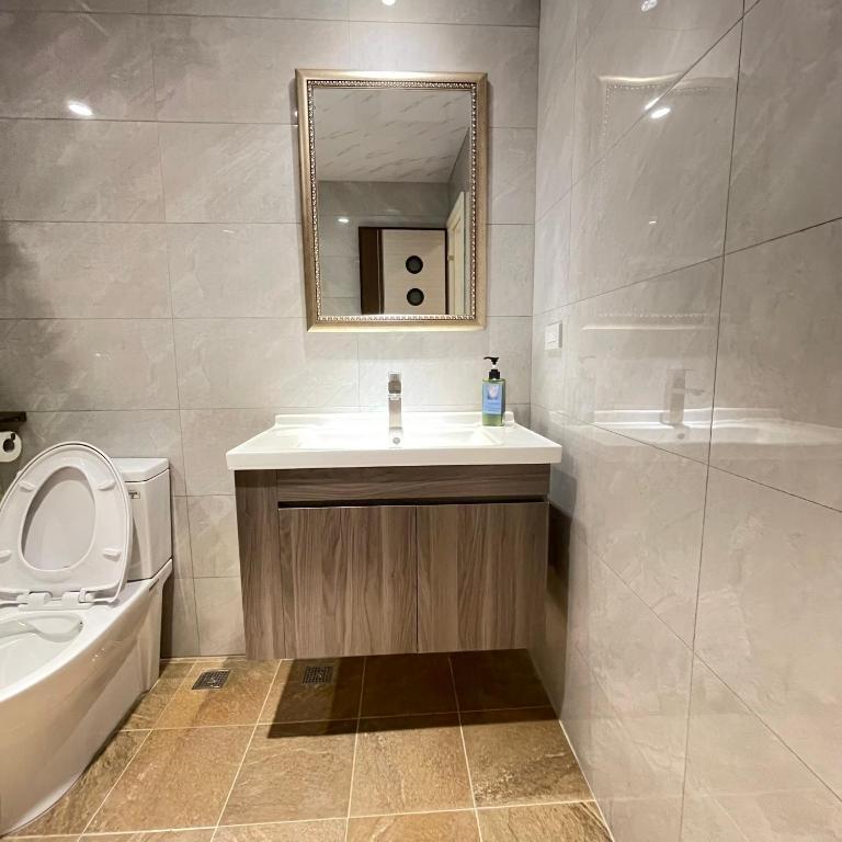 a bathroom with a sink and a toilet and a mirror at 墾丁聚點旅棧 2Ps Hotel in Kenting
