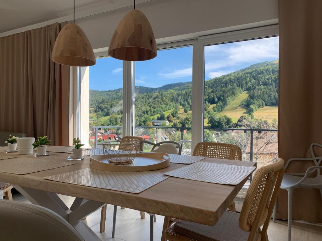 a dining room table with a view of a mountain at Apartament Rentes16 in Szczyrk