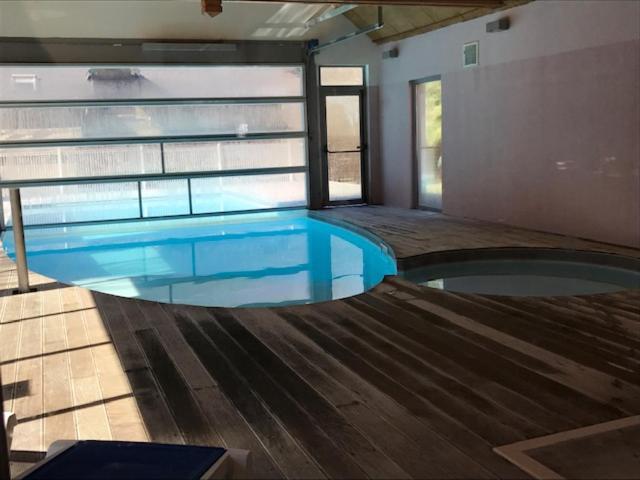 a swimming pool in a house with blue water at Appartement tt confort au coeur des montagnes vue sur les montagnes II Wifi in Luz-Saint-Sauveur